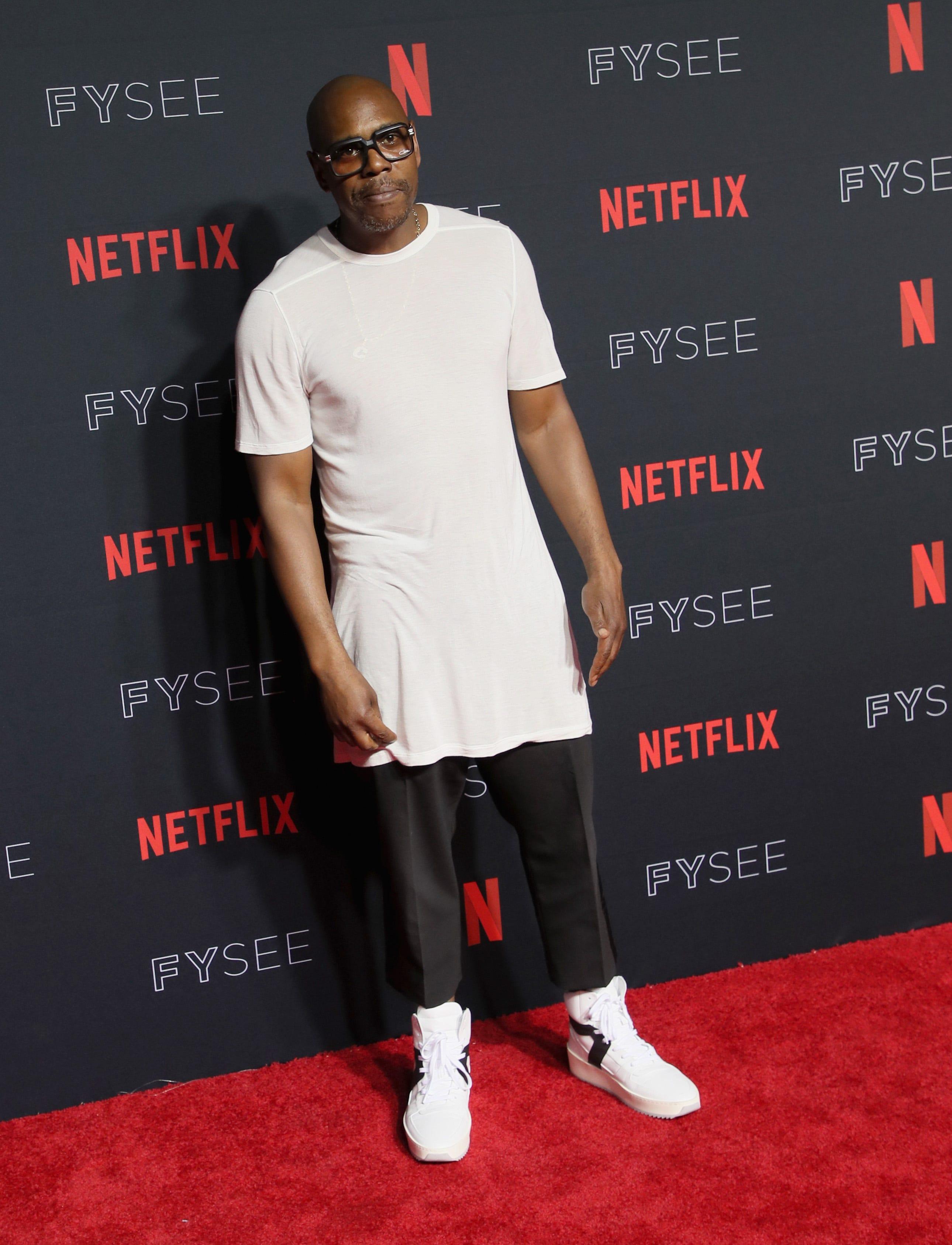 Dave Chappelle sits at the head of the table